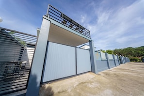 A gated entrance with a metal fence and a concrete pathway leading to a building. - Lark Pool Villa Krabi (Krabi)