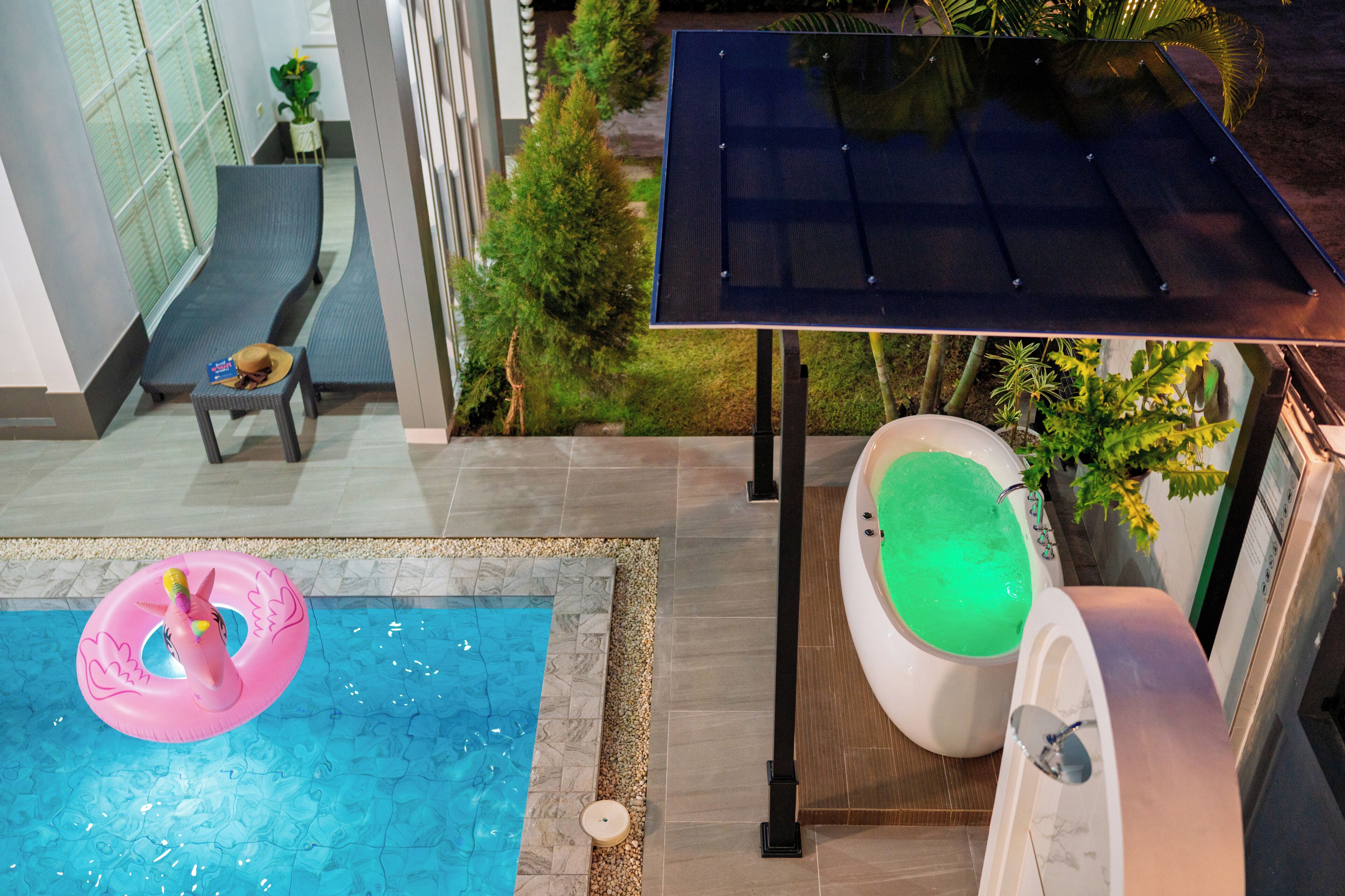 Une piscine avec un flotteur gonflable rose, un jacuzzi avec de l’eau verte et un panneau solaire.