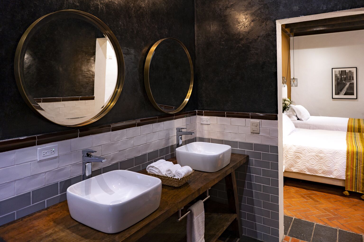 A bathroom with two sinks, a mirror, and a wooden vanity.