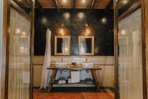 Casa de banho com duas pias, um espelho e um porta-toalhas.