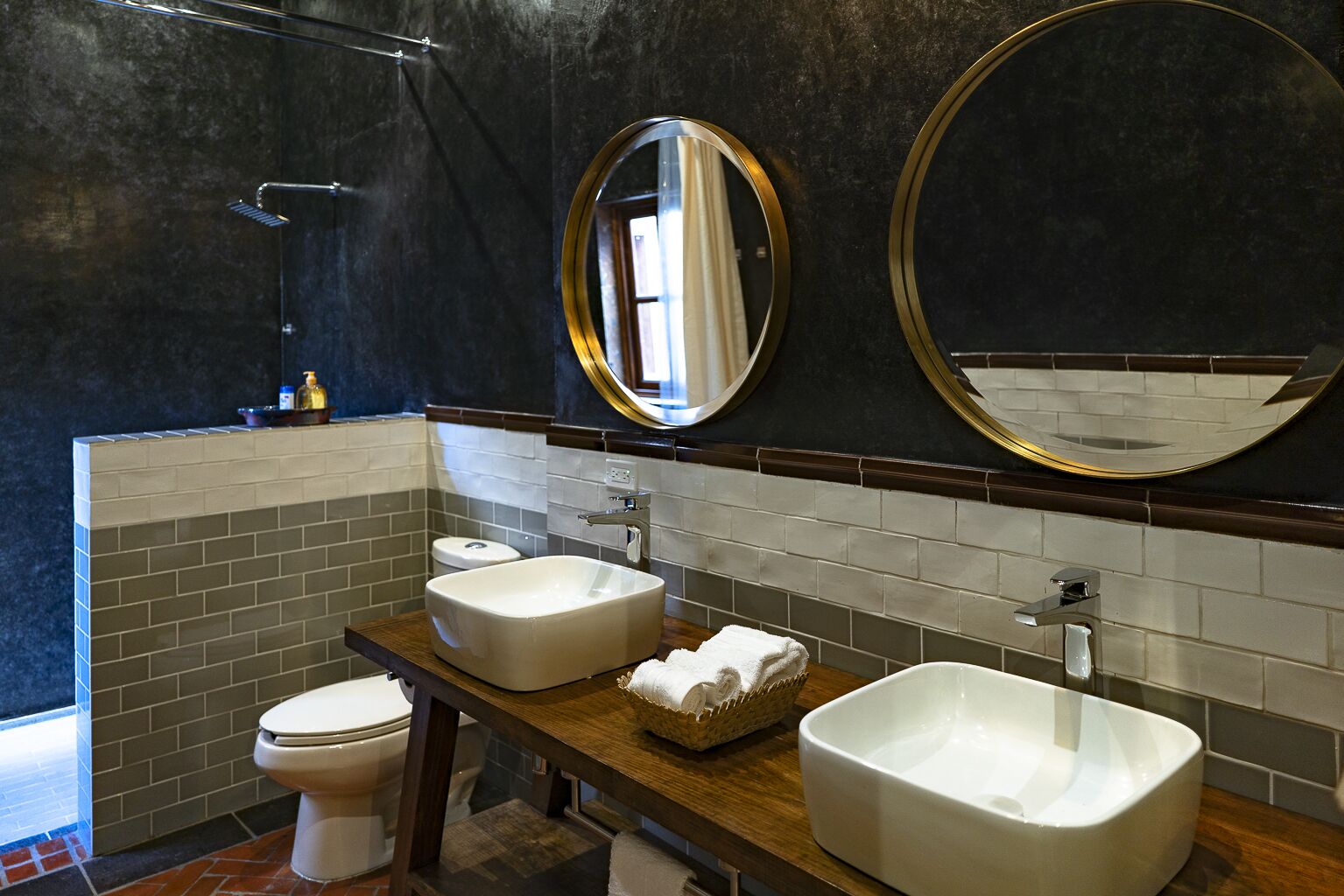 Une salle de bain moderne avec un grand lavabo, deux miroirs, des toilettes et une douche.