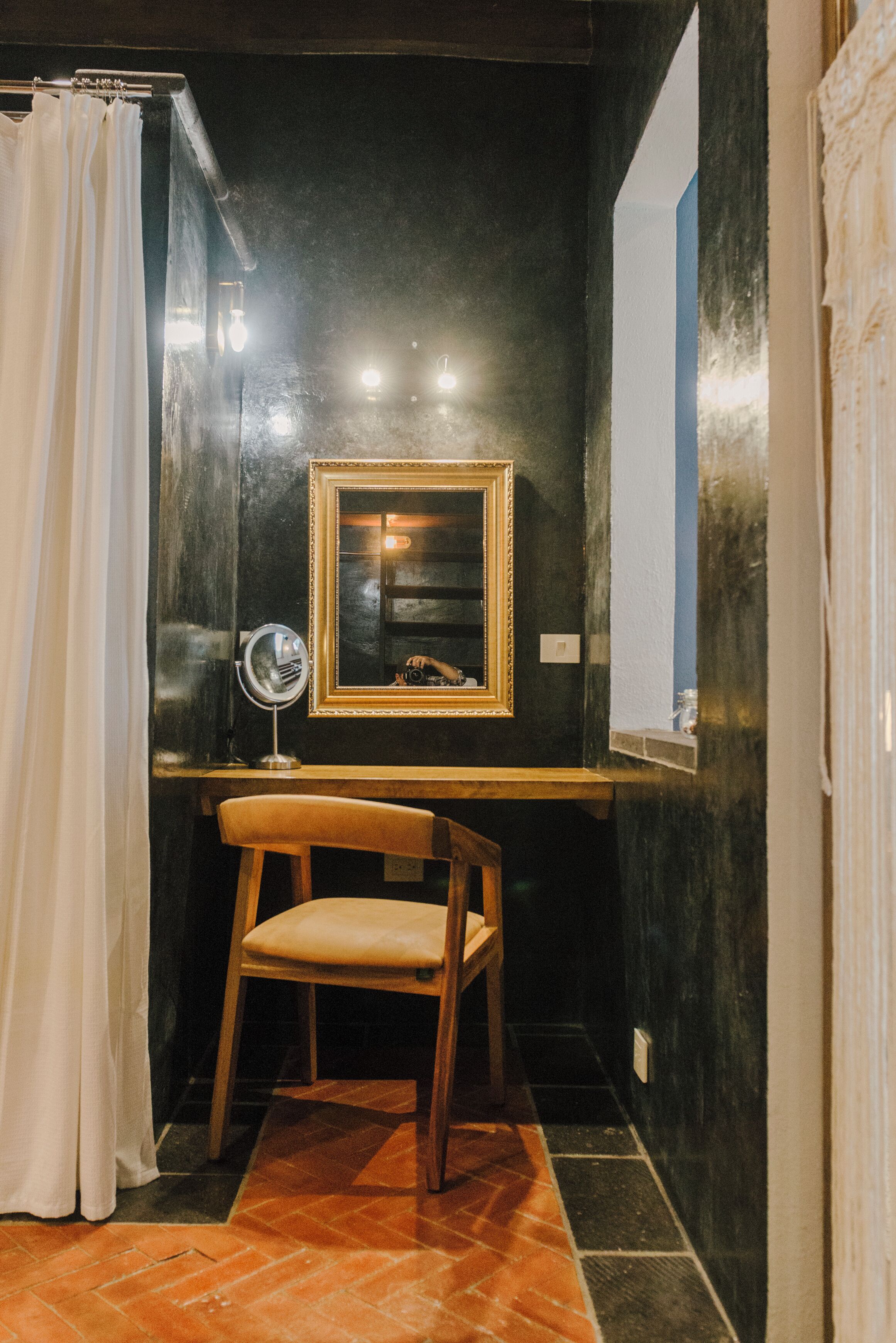 A bathroom with a wooden vanity, a mirror, and a shower curtain.