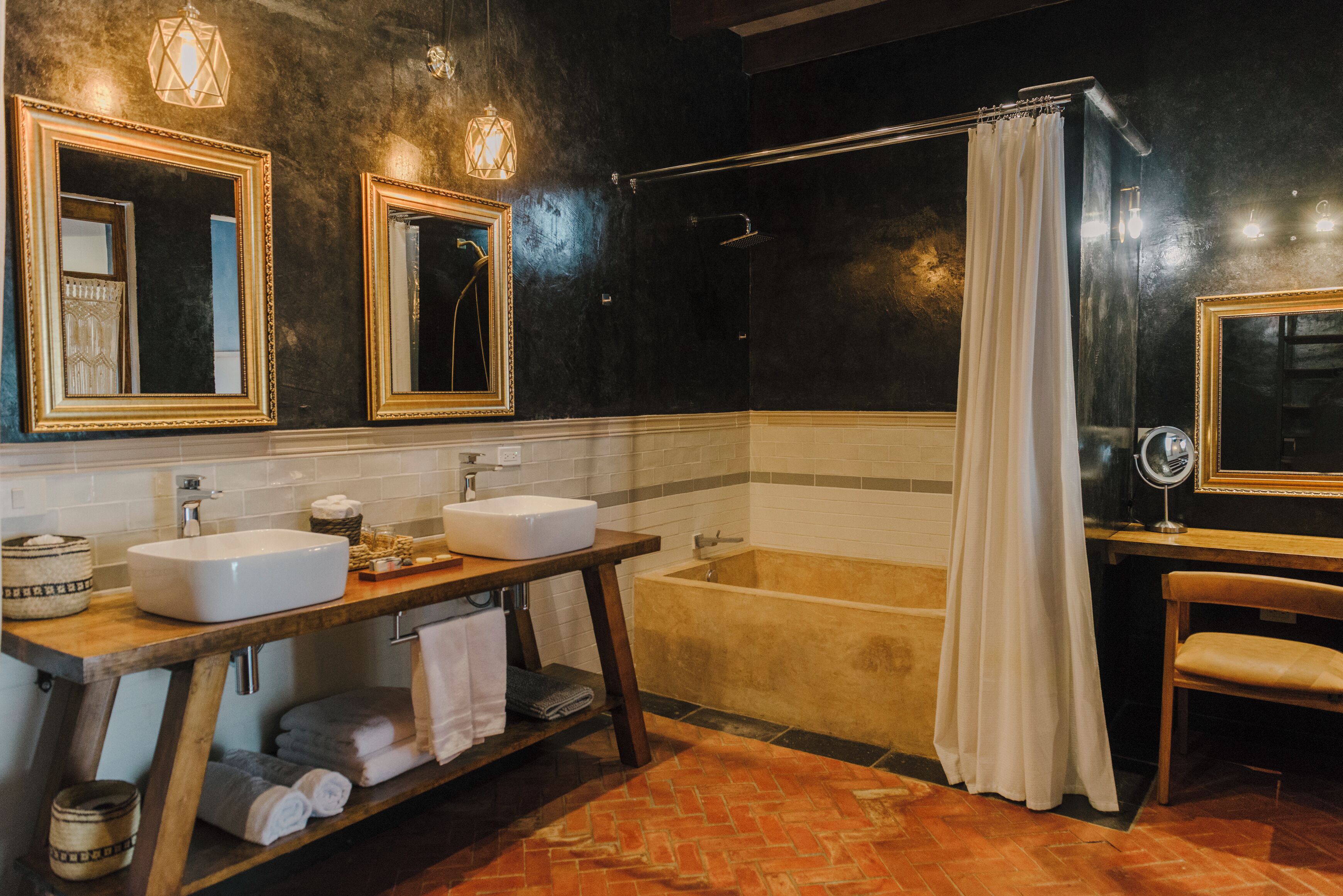 A modern bathroom with two sinks, a bathtub, and a vanity with a mirror.