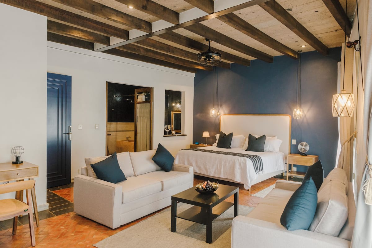 Une chambre d’hôtel moderne équipée d’un grand lit, d’un canapé, d’un bureau et d’une table à manger.