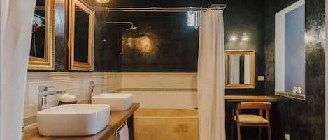 Un baño moderno con dos lavamanos, una bañera y una ducha.
