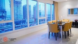 Un comedor moderno con vistas a la ciudad, una mesa con sillas y una ventana con cortinas.