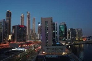 A cityscape with modern high-rise buildings, a river, and a bridge. - Magnificent 3 BR Canal Views (Dubai)