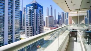 A high-rise building with a glass balcony overlooking a cityscape. - Splendid1BRapartmentinCanalViews (Dubai)