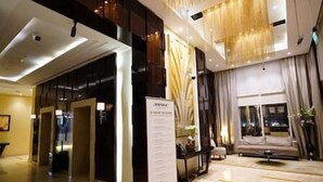 A modern hotel lobby with a reception desk, a seating area, and a large window. - Splendid1BRapartmentinCanalViews (Dubai)