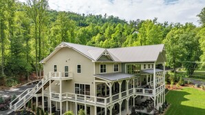 Een huis met twee verdiepingen, een balkon en een overdekte patio.