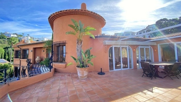 A house with a tiled patio, a potted plant, and a dining area with chairs and a table. - Pretty, luxurious villa with private pool and superb view (Dénia)