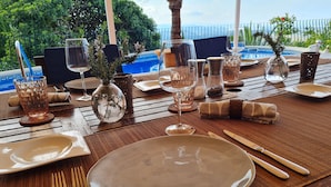A table set for a meal with a view of a pool and greenery. - Pretty, luxurious villa with private pool and superb view (Dénia)
