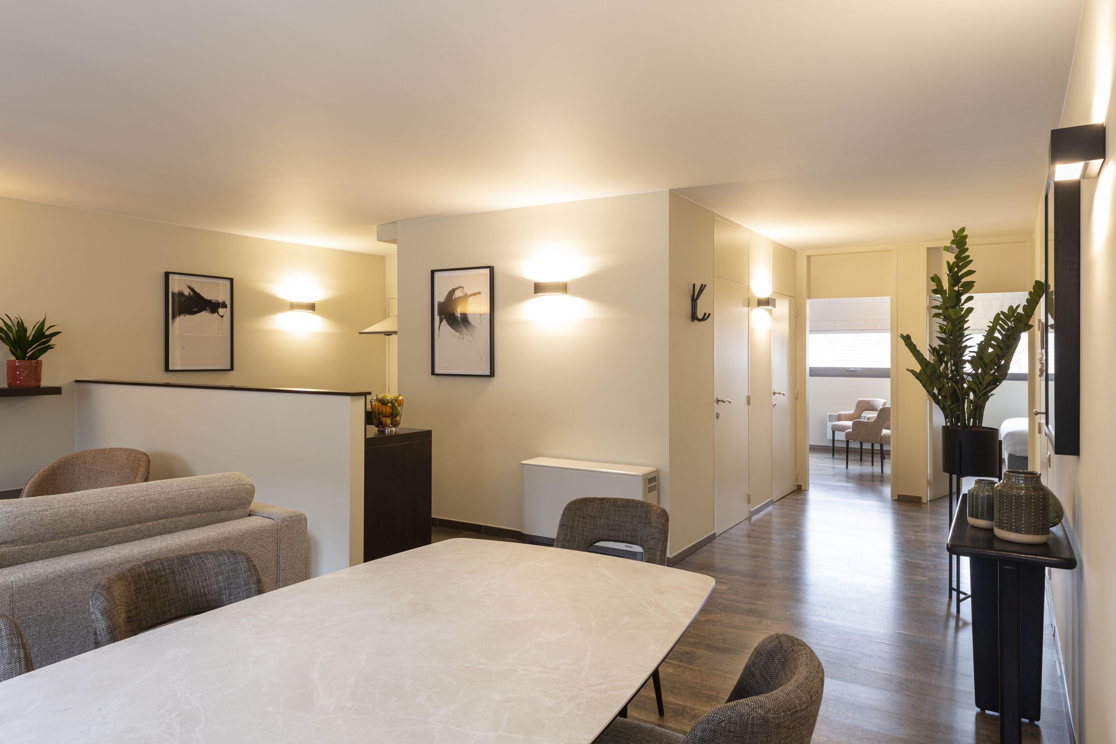 Een moderne hotelkamer met een groot bed, een nachtkastje en een bijzettafeltje. Er is een raam met uitzicht op de stad.