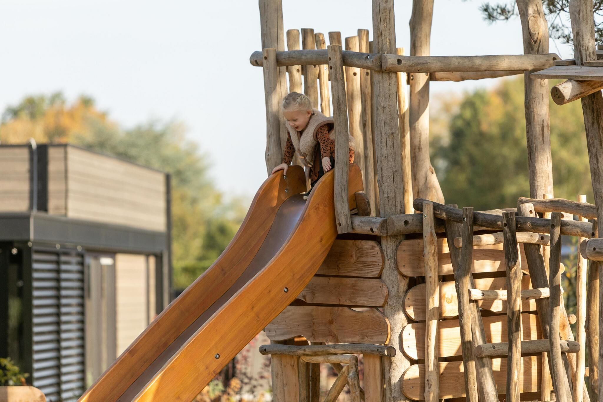 A wooden slide attached to a wooden play structure.