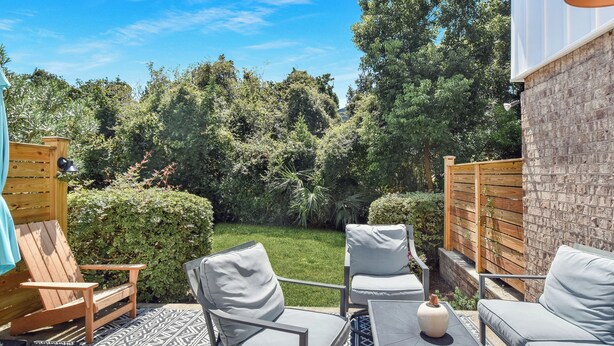 An outdoor seating area with a table, chairs, and a decorative vase. - Less than 1/2 mile to beach. Community pool. (St. Simons Island)