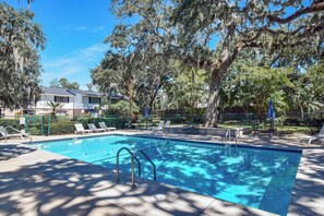 A swimming pool with a no diving sign, surrounded by trees and lounge chairs. - Less than 1/2 mile to beach.  Community pool. (St. Simons Island)