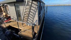 Ein Boot mit Holzboden, Metallgeländern und einer Leiter.