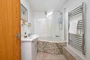 Bathtub, hair dryer, towels, toilet paper