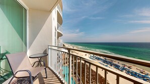 A balcony with a view of the beach, a pool, and a table with chairs. - Aqua 804 ~ Gulf Front ~ Panama City Beach ~ Beach Service Included! (Panama City Beach)