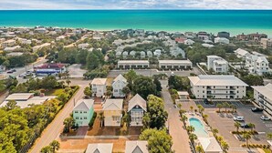 A coastal town with residential buildings, a swimming pool, and a clear view of the ocean.