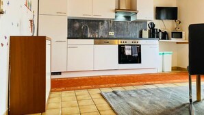 A modern kitchen with white cabinets, a stainless steel range, a microwave, and a built-in oven. - Gerlosblick by Interhome (Zell am Ziller)