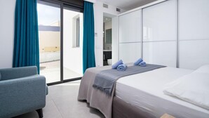 A modern hotel room with a bed, a chair, and a large window with curtains. - La Haya by Interhome (Moraira)
