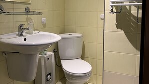 A small bathroom with a sink, toilet, and a mirror. - Garbarska 22 Aparthotel (Kraków)