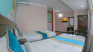 A hotel room with two beds, a television, a desk, and a wardrobe. - Hotel Royal Mantra (Kathmandu)