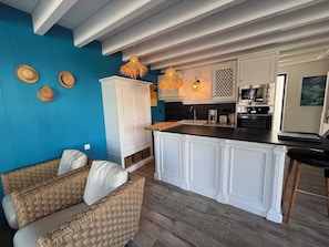 A modern kitchen with white cabinetry, a central island, and a blue accent wall.