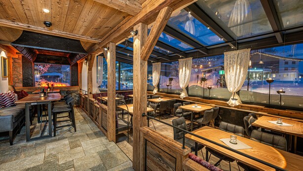 A restaurant with wooden beams, stone flooring, and large windows with curtains. - Hotel Zehnerkar & Hotel Obertauern (Tweng)