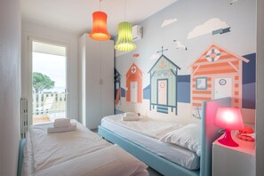 A bedroom with two beds, a balcony, and a mural of houses on the wall. - Swimming pool, barbecue, tennis - 20' min. from Gardaland! (Bardolino)