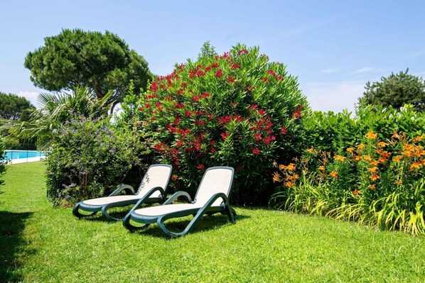 Two lounge chairs in a garden with a pool in the background. - Swimming pool, barbecue, tennis - 20' min. from Gardaland! (Bardolino)