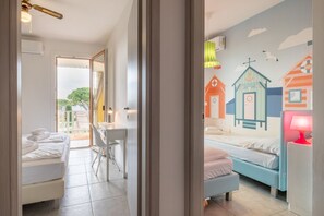 A hotel room with a bed, a desk, and a chair. There is a mural on the wall depicting houses and a lighthouse. - Swimming pool, barbecue, tennis - 20' min. from Gardaland! (Bardolino)