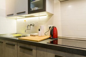 Eine moderne Küche mit Spüle, Arbeitsplatte und einem roten Wasserkocher.