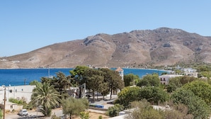 Une ville côtière avec une montagne en arrière-plan, un ciel dégagé et une vue sur la mer.