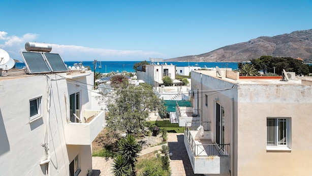 Un quartier résidentiel avec des immeubles, une piscine et une vue sur la mer.