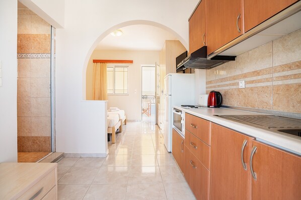 A kitchen with wooden cabinets, a stainless steel range hood, a refrigerator, and a coffee maker.
