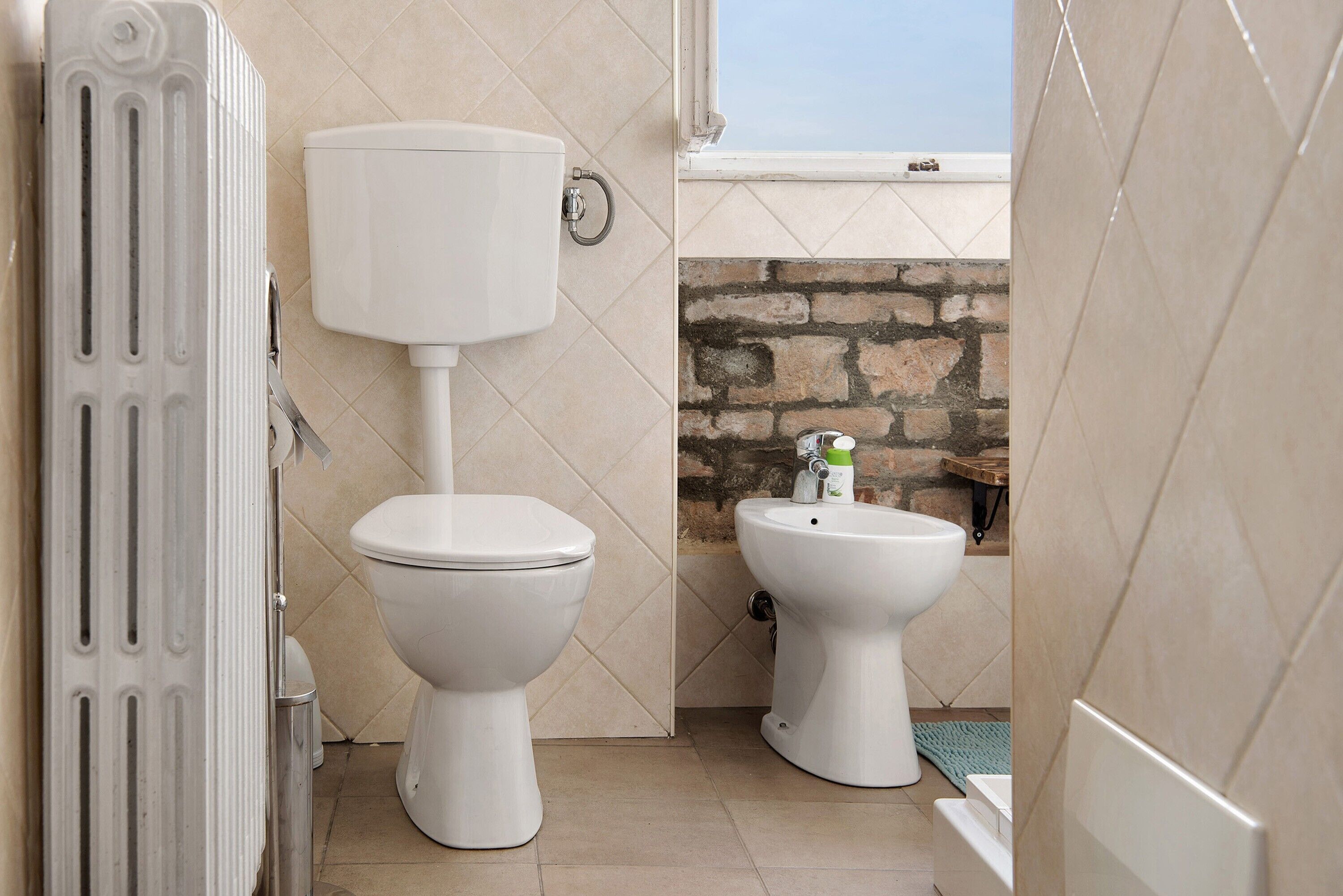 Ein Badezimmer mit Toilette, Bidet und Handtuchheizkörper.