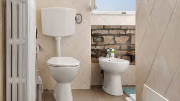 Ein Badezimmer mit Toilette, Bidet und Handtuchheizkörper.