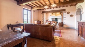 Un interior rústico con una mesa de comedor de madera, un sofá de cuero y una chimenea.