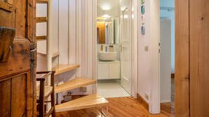 A wooden staircase leading to a bathroom with a white sink and mirror. - Wunderhorn Holiday Home with Private Terrace and Wi-Fi (Civezzano)