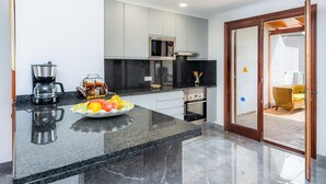 A modern kitchen with a granite countertop, stainless steel appliances, and a fruit bowl. - Apartment 'Cala' with Mountain View, Wi-Fi and Air Conditioning (puerto pollensa)