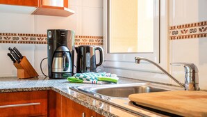 Uma cozinha com bancada de granito, eletrodomésticos de aço inoxidável, armários de madeira e uma janela com vista.