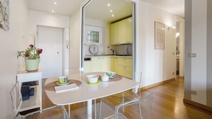 A modern kitchen with yellow cabinets, a dining area with a white table, and a potted plant. - Apartment "Crocetta 10" in City Centre with Wi-Fi (Milano)