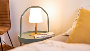 A bedside table with a lamp, a book, and a pen. - Holiday Apartment 'Weitblick Kaltern' with Mountain View, Private Terrace, and Garden (Caldaro sulla strada del vino)