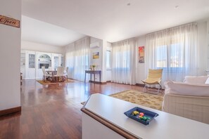 Un amplio salón con una mesa de comedor, sillas, un sofá y una mesa de centro.