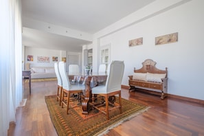 A dining area with a round table, chairs, and a patterned rug.