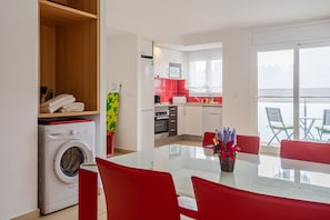 A modern kitchen with a microwave, oven, and red cabinets.