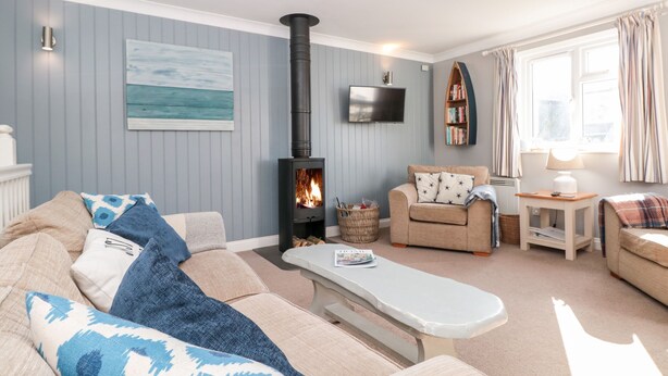 Una sala de estar acogedora con chimenea, un sofá, una mesa de centro y una estantería.