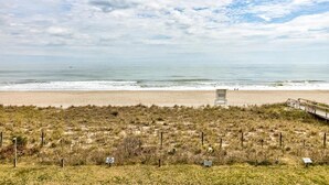 Ein Strand mit Promenadenweg und Rettungsturm.